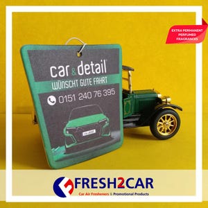 May include: A green and black car air freshener with the text "car & detail" and a phone number. A green vintage car model is next to the air freshener. The text "EXTRA PERMANENT PERFUMED FRAGRANCES" is in a red banner.