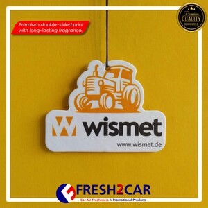 Pu&ograve; includere: Profumatore per auto bianco con un design a trattore arancione, il marchio "wismet" &egrave; stampato sotto. Il testo "Stampa fronte-retro premium con fragranza a lunga durata" &egrave; visibile. Il prodotto &egrave; di FRESH2CAR.