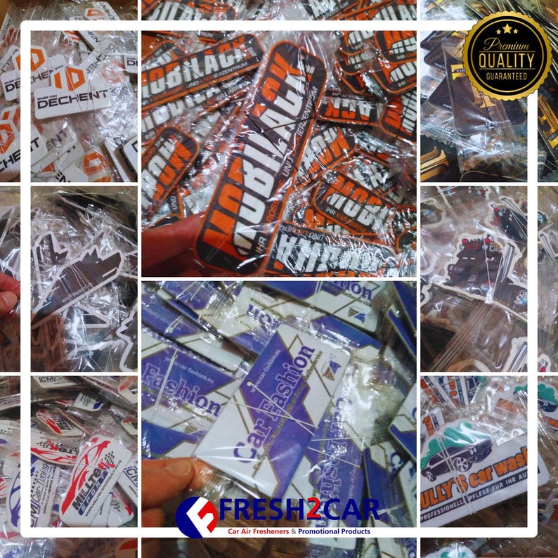 May include: A collection of car air fresheners and promotional products, many in clear packaging. Some feature text like "MOBILAGE" in orange and white, "Car Fashion," and "FRESH2CAR." A "Premium Quality Guaranteed" seal is visible.