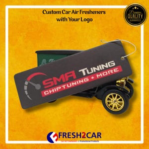Pu&ograve; includere: Un deodorante per auto a forma di auto nera con ruote dorate e un'etichetta con la scritta "SMA TUNING CHIPTUNING + MORE". L'immagine include anche il testo "Custom Car Air Fresheners with Your Logo" e il logo Fresh2Car.
