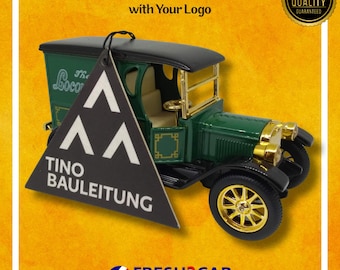 Può includere: Un deodorante per auto vintage verde e oro con tetto e ruote neri. Un'etichetta triangolare nera con testo bianco e un logo è appesa all'auto. Il testo "Custom Car Air Fresheners with Your Logo" è in alto.