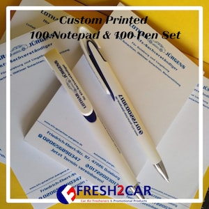 May include: A custom printed notepad and pen set. The set includes 100 notepads and 100 pens. The pens are white with blue accents and the text "LOTHAR JÜRGENS" printed on them. The notepads have the same text and logo.