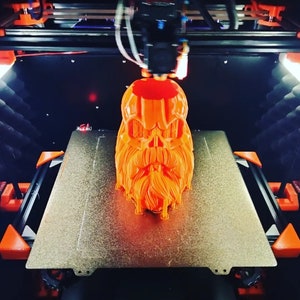 以下が含まれることがあります： オレンジ色の3Dプリントされた頭蓋骨に長いあごひげが印刷されています。