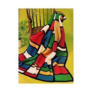 May include: A colorful crocheted blanket with a geometric pattern in shades of red, blue, green, yellow, and white. The blanket is draped over a wooden rocking chair.