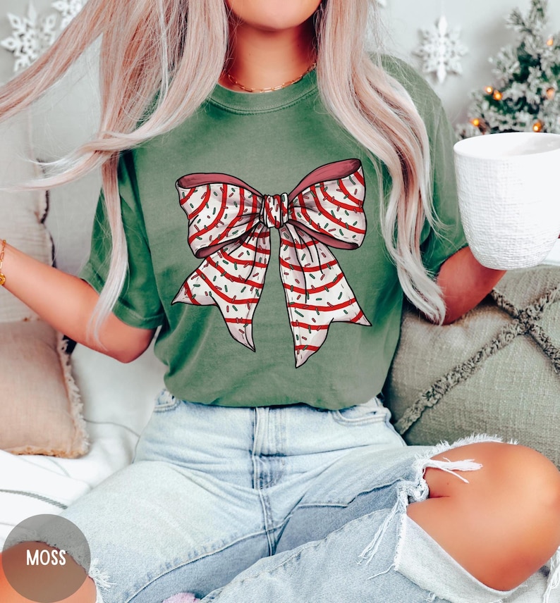 May include: A green t-shirt with a red and white striped bow with green and white sprinkles on it.