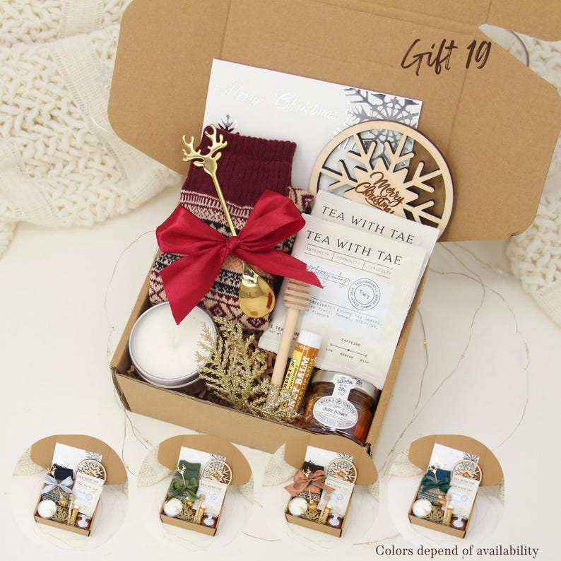 Puede incluir: Una caja de regalo con art&iacute;culos navide&ntilde;os. Incluye calcetines burdeos, un lazo rojo, una vela, un adorno de copo de nieve de madera, t&eacute;, miel y un b&aacute;lsamo labial. La caja es marr&oacute;n y tiene el texto "Gift 10" en la parte superior.