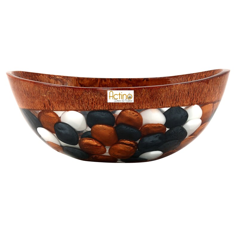 May include: An oval-shaped bowl made of wood and resin with a clear resin layer filled with black, white, and copper colored stones. The bowl has a brown wood rim and the text "Actino Decor & Shop" is visible on the bowl.