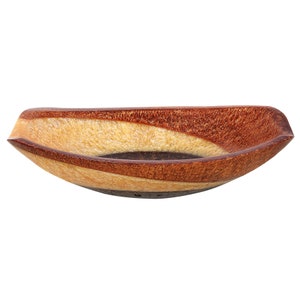 Könnte beinhalten: Eine braune und beige Keramik-Servierschale mit einem wellenförmigen Design. Die Schale ist oval geformt und hat eine glänzende Oberfläche.