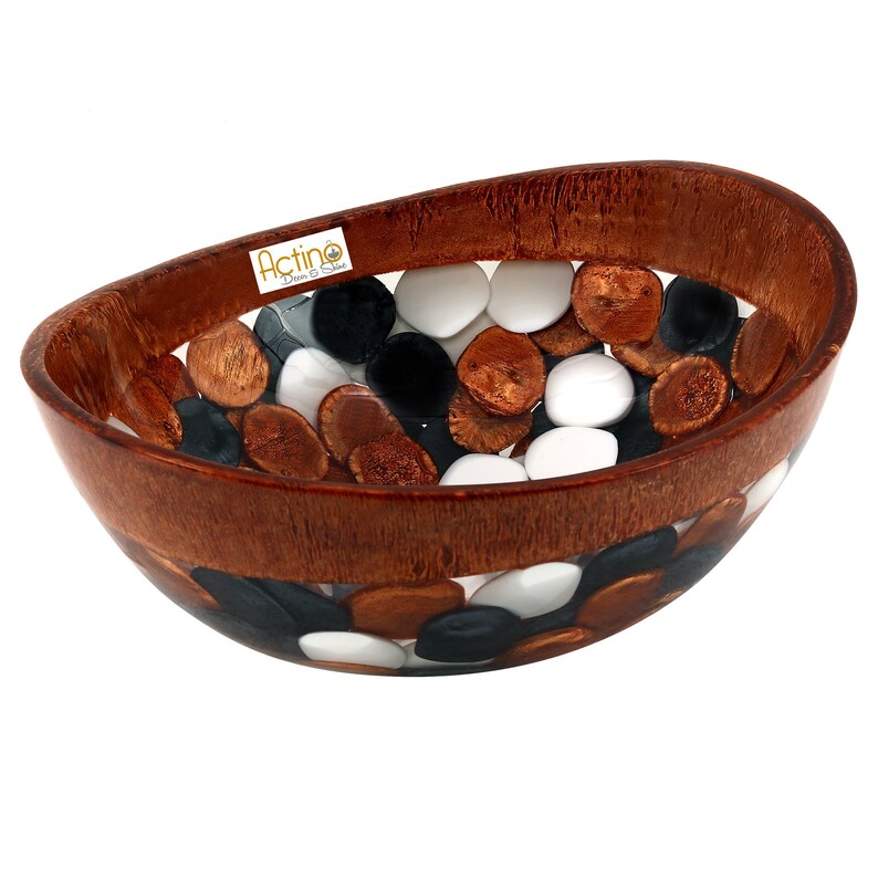 May include: A wooden bowl with a clear resin insert filled with white, black, and brown stones. The bowl is oval shaped and has a brown wood finish. The text "Actino Design & Style" is visible on the bowl.