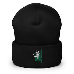 May include: Black beanie with a white embroidered design of a person holding a green pole. The design is on the front of the beanie.