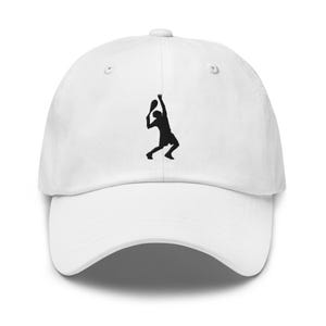 Può includere: Cappellino da baseball bianco con una silhouette nera di un giocatore di tennis che serve una palla.