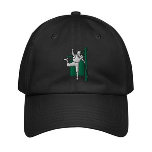 May include: Black baseball cap with an embroidered image of a person hanging from a street lamp. The person is wearing a white shirt and green pants. The street lamp is green and white.