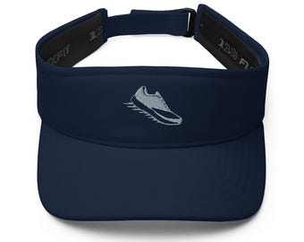 Könnte beinhalten: Marineblaue Sonnenblende mit weißem, gesticktem Laufschuh-Design. Die Sonnenblende hat einen gebogenen Schirm und einen verstellbaren Riemen. Das Innenband ist schwarz mit dem Text "XFIT" und "110 F".