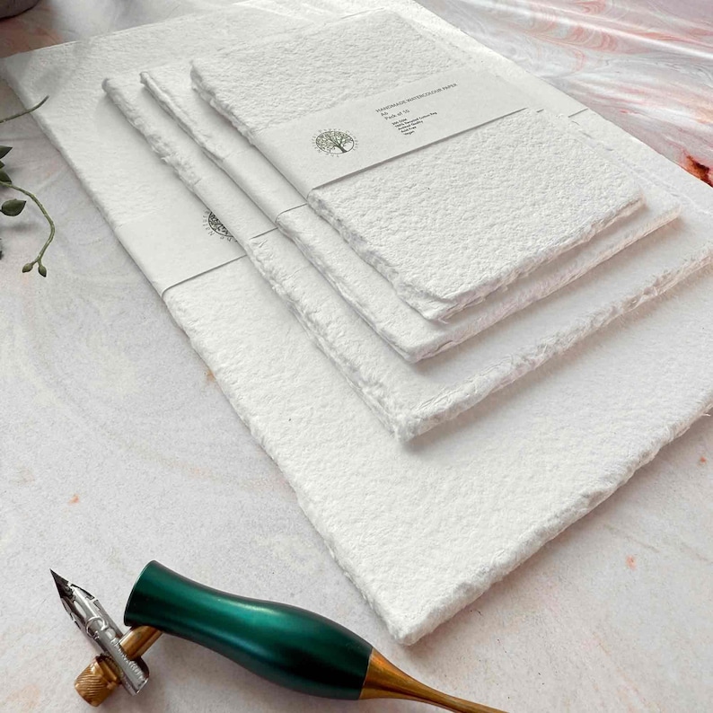 Set of white towels with a decorative tool on a light surface