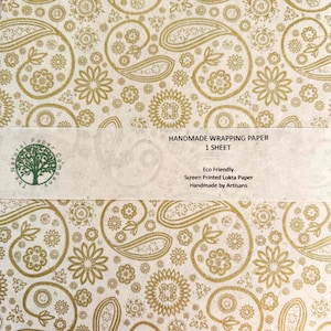 Handmade wrapping paper with gold floral and paisley patterns on a beige background, made from Lokta paper
