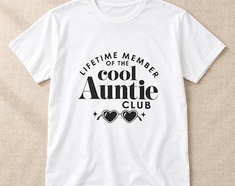 Puede incluir: Una camiseta blanca de manga corta con el texto en negro "LIFETIME MEMBER OF THE cool Auntie CLUB" y un gráfico de gafas de sol en forma de corazón con pequeños detalles de estrellas centrado en la parte delantera.