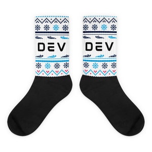 May include: A pair of white crew socks with a black and blue snowflake pattern and the word "DEV" in black. The socks have a black toe and heel.