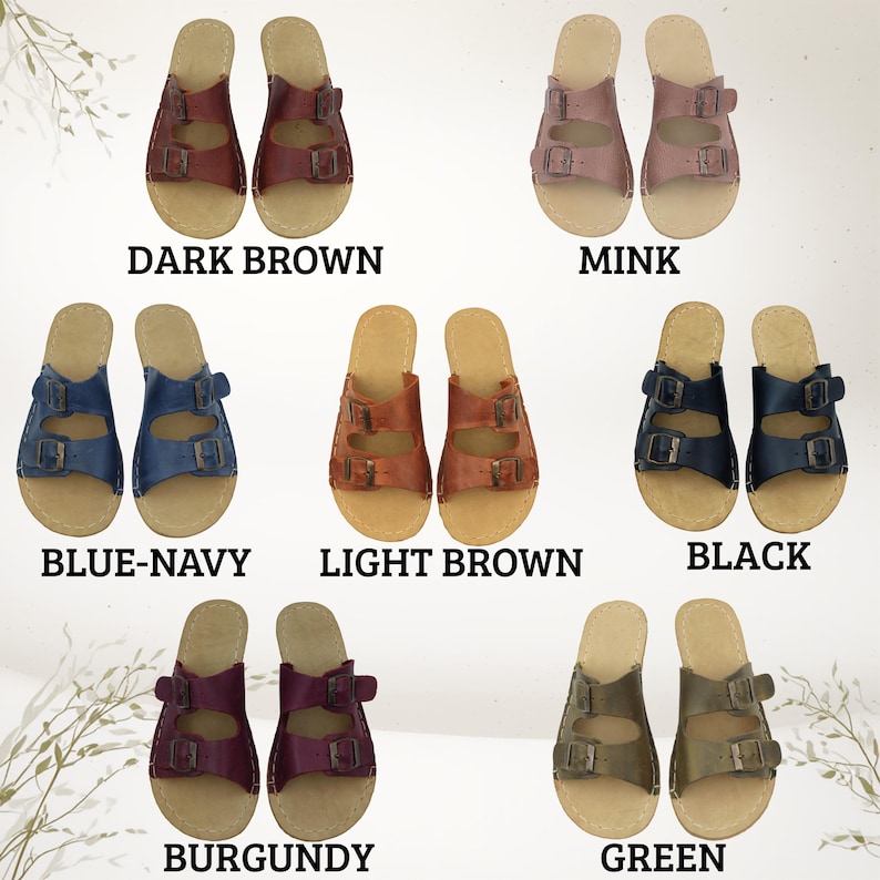 May include: Pairs of leather sandals in various colors, including dark brown, mink, blue-navy, light brown, black, burgundy, and green. Each sandal features a double-strap design with buckle closures and a light-colored footbed. The color names are displayed below each pair.