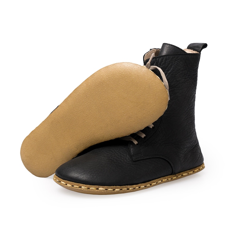 May include: Black leather ankle boots with a lace-up closure and a brown rubber sole.