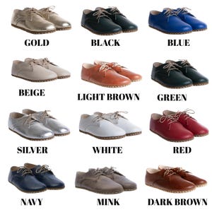 May include: A collection of twelve pairs of lace-up oxford shoes in various colours including gold, black, blue, beige, light brown, green, silver, white, red, navy, mink, and dark brown. Each pair features a rounded toe and light-coloured laces.