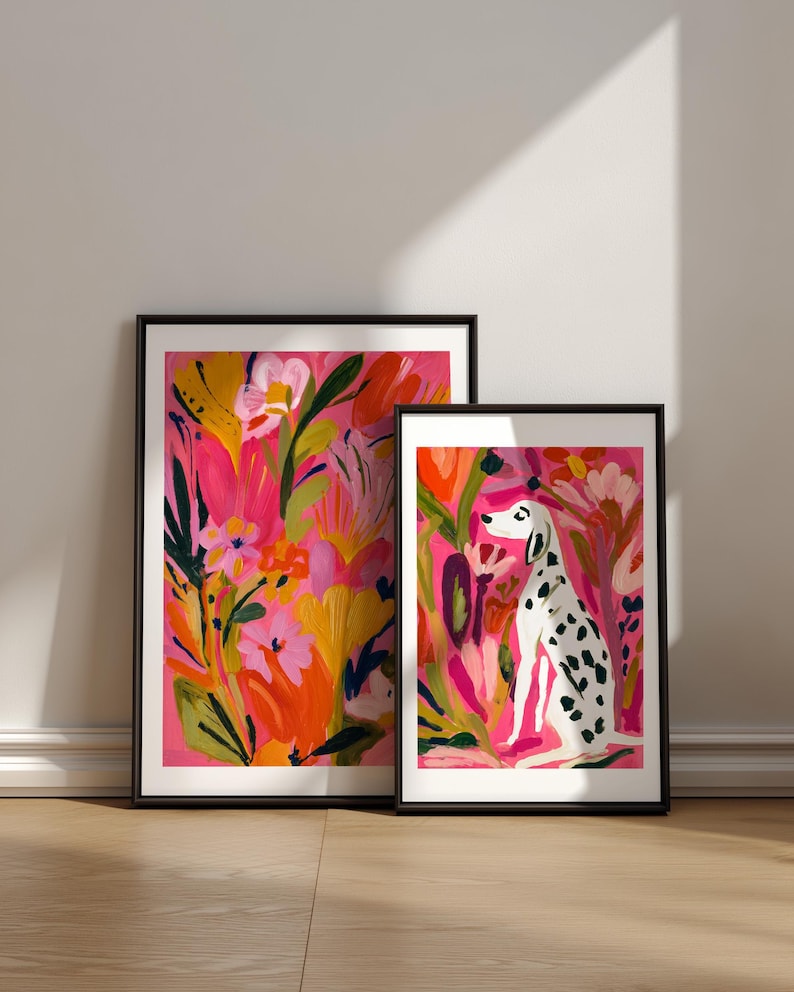 May include: Two framed art prints with black borders. The larger print features a vibrant floral pattern in shades of pink, orange, and yellow. The smaller print depicts a white dog with black spots sitting amidst a colorful garden of flowers.