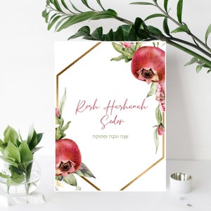 Peut inclure: Une carte imprimable blanche avec un cadre hexagonal doré et des illustrations de grenade à l'aquarelle. Le texte indique "Rosh Hashanah Seder" et " שנה טובה ומתוקה".