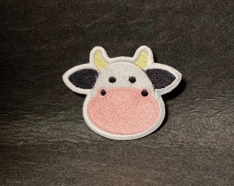 May include: White embroidered cow patch with black spots and pink nose.