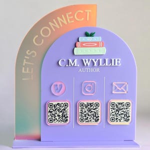 Può includere: Un cartello in acrilico viola e arancione con la scritta "LET'S CONNECT" e "C.M. WYLLIE AUTHOR". Il cartello presenta icone di social media, codici QR e una pila di libri. Il cartello è progettato per stare in piedi.