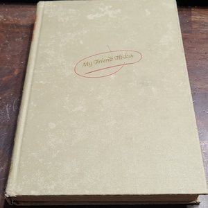 May include: A green book with the title "My Friend Flicka" written in cursive on the front cover.