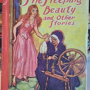 Op de afbeelding: Omslag van een vintage kinderboek met de titel "The Sleeping Beauty and Other Stories". De illustratie toont een vrouw in een roze jurk en een oudere vrouw met een spinnewiel. De titel staat in rode letters.