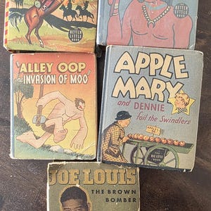 May include: A collection of vintage "Big Little Books" with colorful covers. Titles include "Tim Tyler's Luck," "Flame Boy and Indians Secret," "Alley Oop," "Apple Mary," and "Joe Louis." The books are in various conditions.