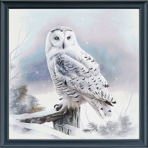 May include: A snowy owl with white and gray feathers perches on a wooden fence post in a snowy winter landscape.