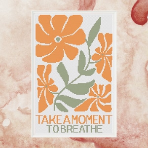 Puede incluir: Patrón de punto de cruz con flores naranjas y hojas verdes con el texto "Tómate un momento para respirar".