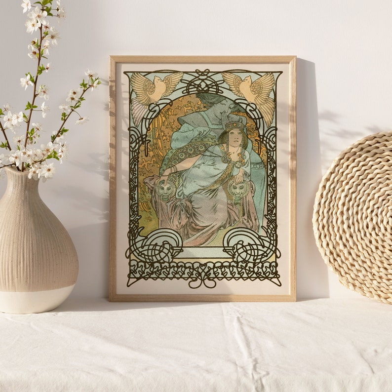 May include: A framed art print featuring a woman in a flowing gown, surrounded by intricate floral and bird motifs. The artwork is in a vintage style with a muted color palette of greens, blues, and golds.