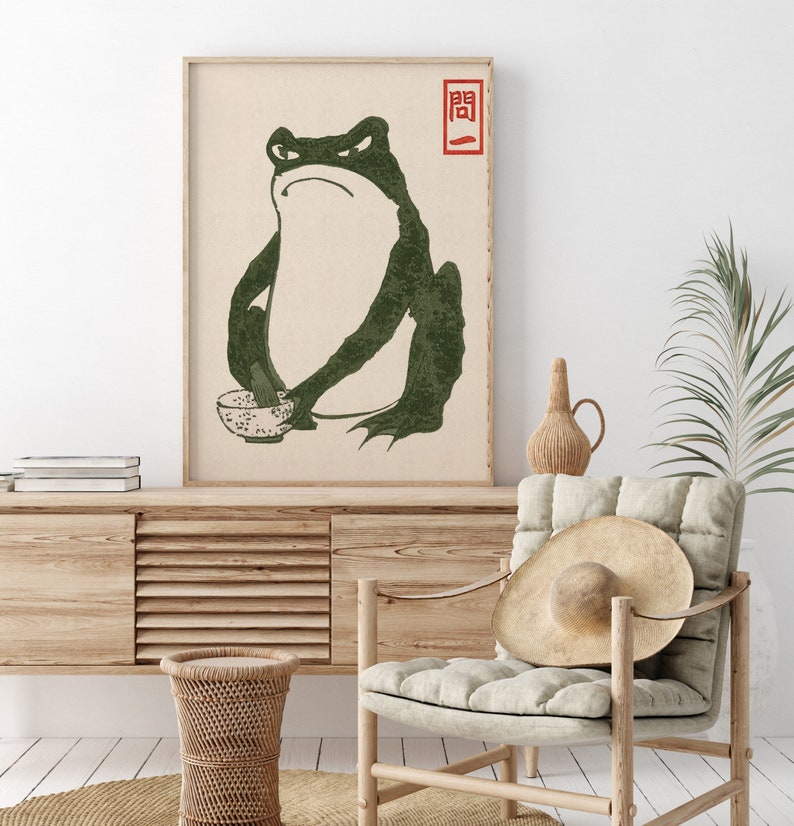 May include: A vintage-style print of a green frog holding a bowl, with the Japanese character "関" in red above the frog.