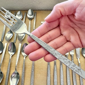 以下が含まれることがあります： 柄に花柄が施されたカトラリーセット。フォークとスプーンが含まれています。