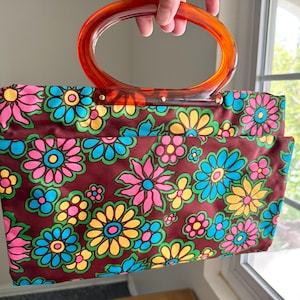 Bolso de mano Lady’s Pride Groovy ajustable con diseño floral de satén burdeos y cierre a presión con asas de metacrilato en rosa brillante, azul, amarillo y naranja, estilo años 60