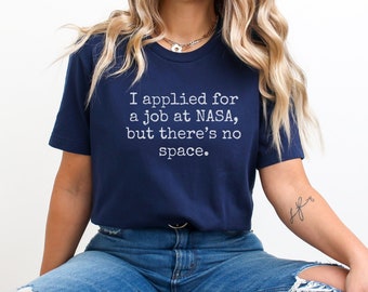 May include: A navy blue t-shirt with the text "I applied for a job at NASA, but there's no space." printed in white.