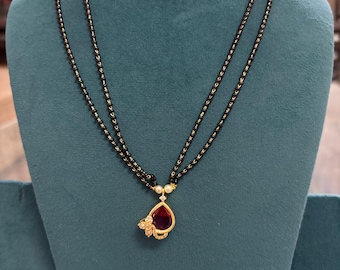 Collar de cuentas negras con joya india chapada en oro y diamantes de circonita cúbica.