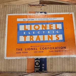 Puede incluir: Caja de cartón con una etiqueta vintage de Lionel Electric Trains. La etiqueta naranja y azul muestra "Lionel Electric Trains" y "The Lionel Corporation". La caja está marcada con "No. 273W".