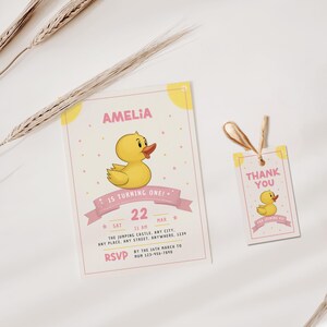 May include: A pink and yellow birthday invitation with a cartoon yellow rubber ducky. The invitation says "Amelia is turning one!" and includes the date and time of the party. A matching thank you tag is also included.