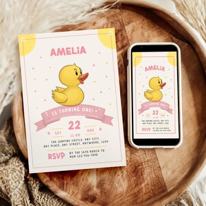 May include: A pink and yellow birthday invitation with a cartoon yellow rubber duck. The invitation says "Amelia is turning one!" and includes the date "Sat 22 Mar 11 AM" and the location "The Jumping Castle, Any City, Any Place, Any Street, Anywhere, 1234".