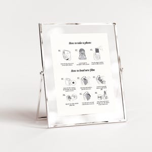 Puede incluir: Una gu&iacute;a ilustrada en blanco y negro sobre c&oacute;mo tomar una foto y cargar una pel&iacute;cula nueva en una c&aacute;mara instant&aacute;nea. La gu&iacute;a incluye pasos numerados con ilustraciones de la c&aacute;mara y la pel&iacute;cula.