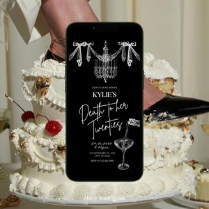 May include: A black smartphone with a white invitation on the screen. The invitation reads "Join us as we mourn Kylie's Death to her Twenties" with a date, time, and address. The phone is partially obscured by a white cake with red cherries.
