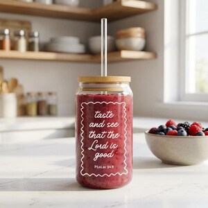 May include: A clear glass jar with a bamboo lid and a clear straw, filled with a red smoothie. The jar has white text that reads "taste and see that the Lord is good" with "Psalm 34:8" below. A bowl of berries is next to the jar.