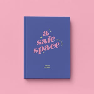 May include: A hardcover journal with a blue cover and the words "a safe space" in pink script. The text "for my thoughts" is in a smaller font, and the name "Piper's Journal" is at the bottom. The background is pink.