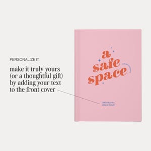 May include: A pink journal with the words "a safe space" in orange script. The journal also has the text "FOR MY THOUGHTS" and "BROOKLYN'S BRAIN DUMP". The journal is a thoughtful gift.