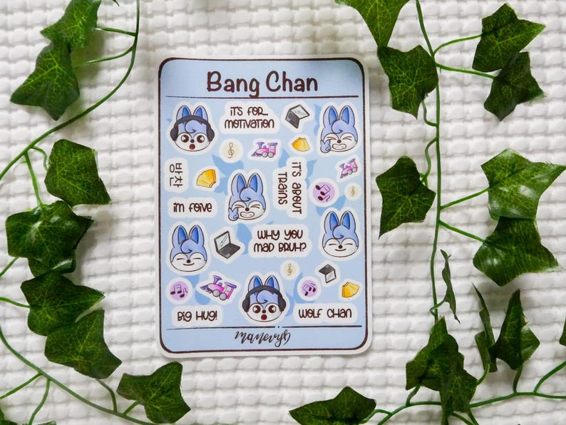 May include: A rectangular sticker sheet titled Bang Chan featuring multiple small illustrations of a blue-haired wolf character, trains, laptops, and musical notes. Text includes "IT'S FOR MOTIVATION," "IT'S ABOUT TRAINS," "WHY YOU MAD BRUH?," "BIG HUG!," and "WOLF CHAN."