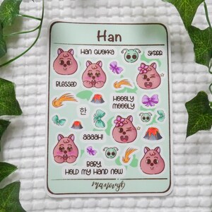May include: A sticker sheet with a light green background featuring various cartoon images and text. The images include pink bear-like characters, butterflies, volcanoes, and shooting stars. Text includes "Han", "Blessed", "Baby, Hold My Hand Now", and other phrases.