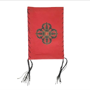 May include: A red leather-bound journal with black stitching and tassels. The cover features a black and gold mandala design.